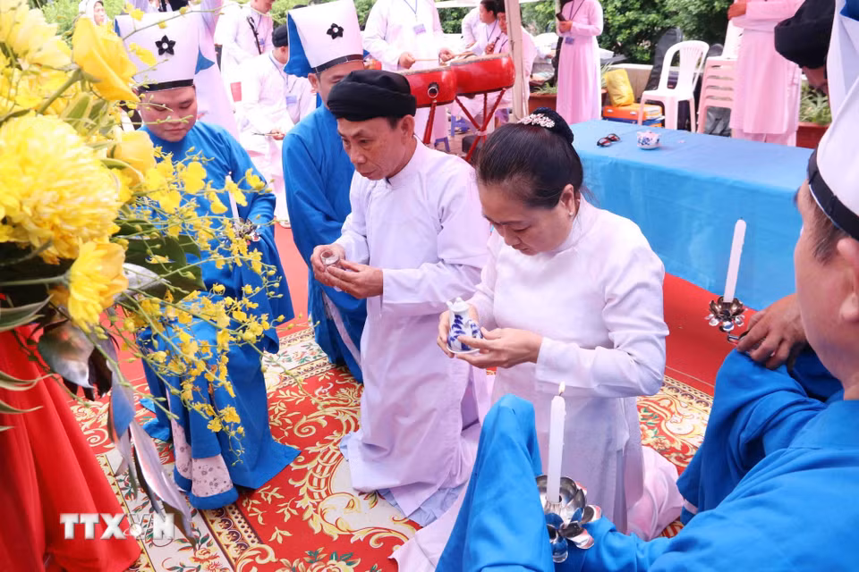Nghi lễ dâng rượu theo nghi lễ đạo Cao Đài tại lễ cầu siêu các Anh hùng liệt sỹ tại Công viên Lê Thị Riêng. (Ảnh: Xuân Khu/TTXVN)