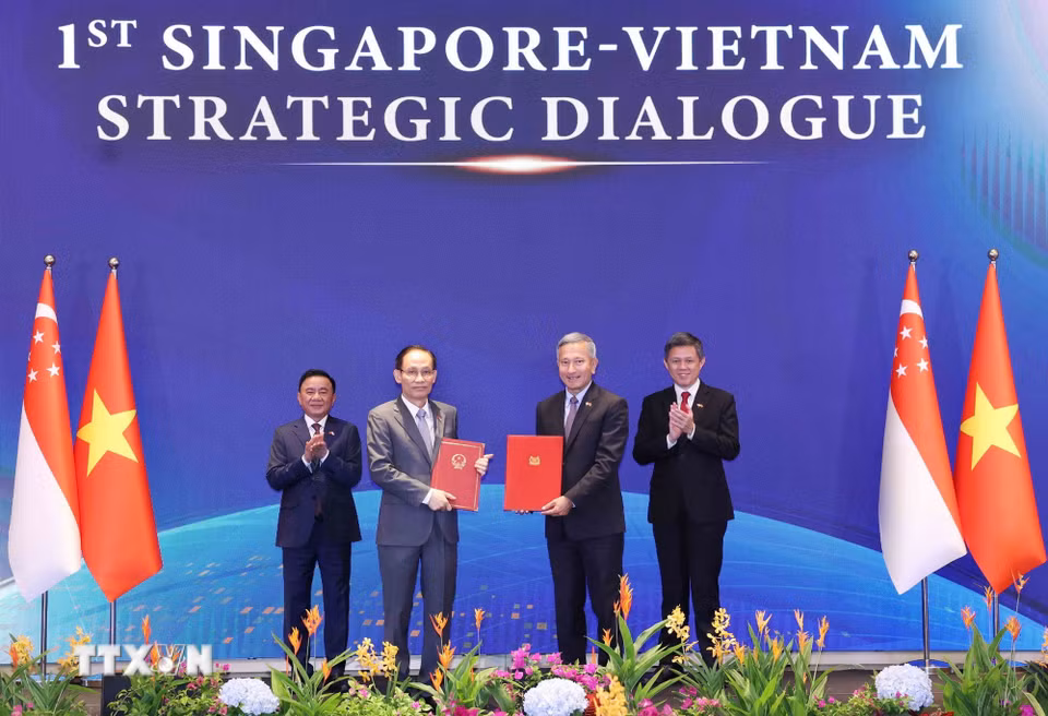 Uỷ viên Bộ Chính trị, Bộ trưởng Ngoại giao Lê Hoài Trung và Bộ trưởng Ngoại giao Singapore Vivian Balakrishnan trao Bản ghi nhớ hợp tác giữa hai Đảng. (Ảnh: Phương Hoa/TTXVN)