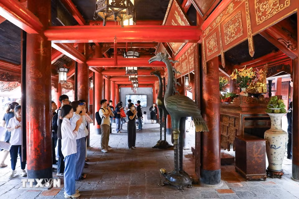 Thí sinh và người nhà dâng hương cầu may tại Văn Miếu-Quốc Tử Giám. (Ảnh: Lê Đông/TTXVN)