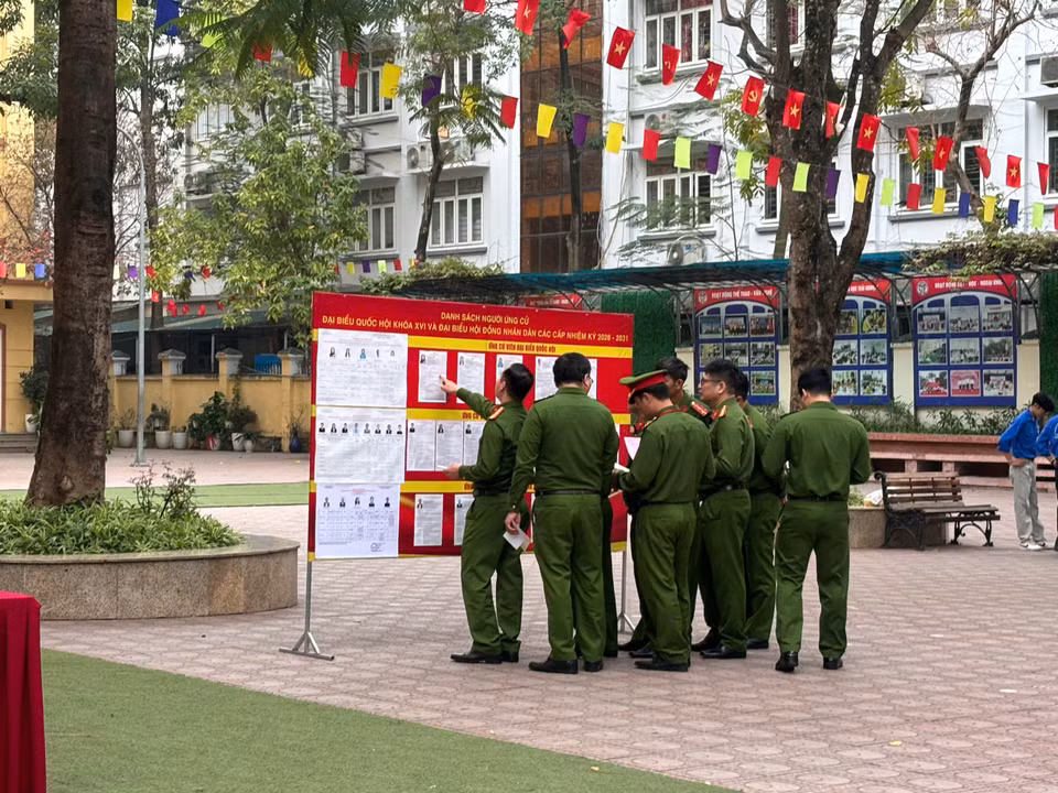 Các cử tri nghiên cứu tiểu sử các ứng viên. (Ảnh: Thu Hương/Vietnam+)