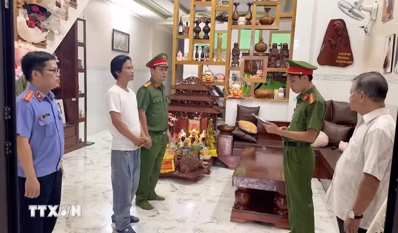 Lực lượng chức năng đọc lệnh khởi tố vụ án, khởi tố bị can. (Ảnh: TTXVN phát)