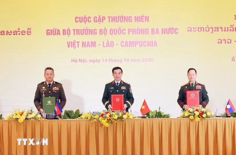 Phó Thủ tướng, Bộ trưởng Bộ Quốc phòng ba nước ký Biên bản cuộc gặp. (Ảnh: Trọng Đức/TTXVN)