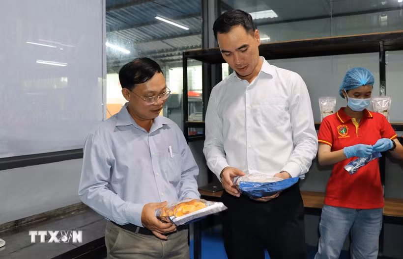 Đại diện Công ty Trách nhiệm hữu Sản xuất Thương mại Dịch vụ ABC Việt Nam giới thiệu các sản phẩm được từ các thiết bị máy móc hiện đại vừa được đầu tư. (Ảnh: Thanh Hòa/TTXVN)