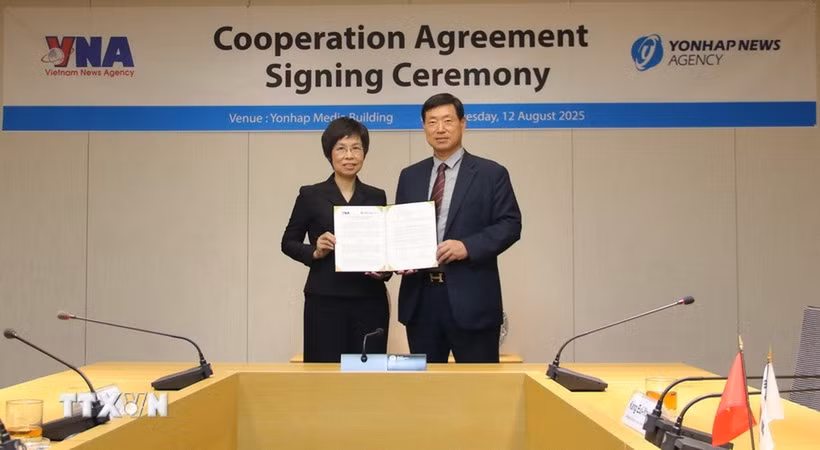 Tổng Giám đốc TTXVN Vũ Việt Trang và Chủ tịch Yonhap Hwang Dae Il công bố Văn kiện ký kết. (Ảnh: Đức Thắng/TTXVN)