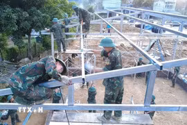 Các chiến sỹ Bộ chỉ huy Quân sự tỉnh Lai Châu làm việc xuyên ngày đêm để hoàn thành 24 căn nhà cho người dân. (Ảnh: Nguyễn Oanh/TTXVN)
