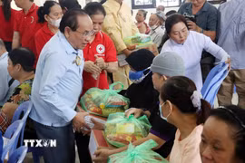 Ông Nguyễn Hữu Nhơn, Chánh Hội trưởng Nam Thành Thánh thất, trao tặng quà mùa Vu Lan cho người khuyết tật nghèo. (Ảnh: Tiến Lực/TTXVN)