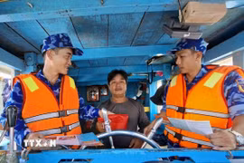 Lực lượng chấp pháp trên biển tại Thành phố Hồ Chí Minh tuyên truyền về chống khai thác IUU cho ngư dân. (Ảnh: Hoàng Nhị/TTXVN)