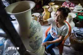 Công đoạn tạo hoa văn cho sản phẩm gốm Bát Tràng. (Ảnh: Trọng Đạt/TTXVN)