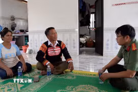 Ông Siu Un trao đổi với Công an cơ sở để vận động người dân từ bỏ tà đạo chung tay gìn giữ bình yên thôn, làng. (Ảnh: Hoài Nam/TTXVN)