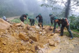 Cán bộ, chiến sỹ dọn dẹp đất đá, cây cối đổ gãy, khôi phục các tuyến giao thông tại xã Mù Cang Chải. (Ảnh: TTXVN phát)