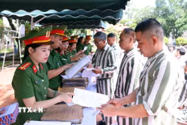 Cán bộ trại giam Phú Sơn 4 (Bộ Công an) trao giấy chứng nhận đặc xá cho người được đặc xá (đợt 2) năm 2025. (Ảnh: Phạm Kiên/TTXVN)