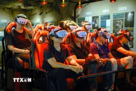 Khách tham quan trải nghiệm tour thám hiểm hang động Sơn Đoòng bằng công nghệ thực tế ảo (VR 5D). (Ảnh: Tá Chuyên/TTXVN)