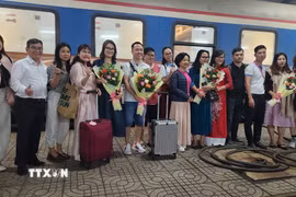 Bà Nguyễn Thị Kim Chung Phó Giám đốc sở Văn hóa Thể thao và Du lịch tỉnh Bình Định tặng hoa cho du khách. (Ảnh: Sỹ Thắng/TTXVN)