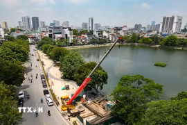 Đơn vị thi công sử dụng máy cẩu cọc thép và máy ép cừ để triển khai các hạng mục nền móng tại dự án nâng cấp trạm bơm hồ Xã Đàn, góp phần đẩy nhanh tiến độ công trình chống ngập. (Ảnh: Lê Đông/TTXVN)