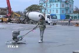 Công nhân hoàn thiện mặt bằng để chuẩn bị cho sự kiện công bố bộ nhận diện thương hiệu du lịch biển Giao Ninh. (Ảnh: Công Luật/TTXVN)
