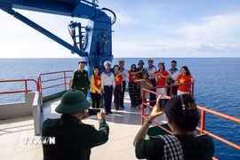 Hình ảnh cờ Tổ quốc trở thành cầu nối giữa đất liền và biển đảo. (Ảnh: Xuân Quý/TTXVN)