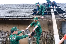 Lực lượng Đồn Biên phòng Tùng Vài (Tuyên Quang) giúp người dân lợp lại mái nhà cho người dân bị ảnh hưởng của mưa đá, dông lốc. (Ảnh: Đức Thọ/TTXVN)
