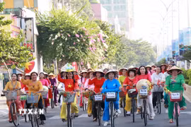 Phụ nữ Khánh Hòa tham gia lễ hội diễu hành áo dài bằng xe đạp. (Ảnh: Phan Sáu/TTXVN)