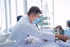 Bác sỹ Trần Thanh Linh, Trưởng Khoa Hồi sức tích cực, Bệnh viện Chợ Rẫy, điều trị cho nạn nhân. (Ảnh: TTXVN phát)