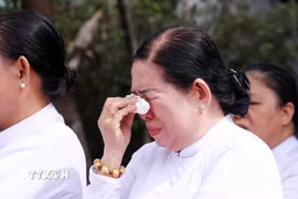 Nỗi xúc động của các tín hữu đạo Cao Đài trước anh linh các anh hùng liệt sỹ được quy tập tại Công viên Lê Thị Riêng. (Ảnh: Xuân Khu/TTXVN)