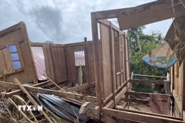 Một phần ngôi nhà bị lât ngược do nước lũ cuốn. (Ảnh: Văn Tý/TTXVN)