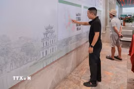 Người dân nghiên cứu kỹ các nội dung đóng góp cho quy hoạch hồ Gươm. (Ảnh: Phan Phương/TTXVN)