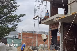 Người dân tất bật thi công nhà cửa tại khu tái định cư. (Ảnh: Đình Quân/TTXVN)