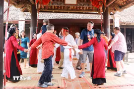 Du khách quốc tế cùng các nghệ nhân và người dân tham gia Hát Xoan tại đình cổ Hùng Lô (xã Hùng Lô, thành phố Việt Trì, tỉnh Phú Thọ). (Ảnh: Trung Kiên/TTXVN)
