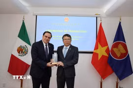 Đại sứ Việt Nam tại Mexico Nguyễn Văn Hải trao giải cho tác giả Mouris Salloum George. (Ảnh: Phi Hùng/TTXVN)
