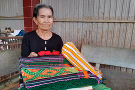 Nghệ nhân Thị Y Rơ (76 tuổi, người dân tộc M’nông) với tấm thổ cẩm đã dệt hoàn chỉnh. (Ảnh: K GỬIH/TTXVN)