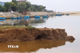 Những khối đất lớn liên tục bị cuốn trôi xuống lòng sông. (Ảnh: Đinh Hương/TTXVN)