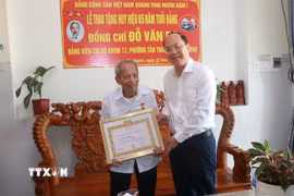 Bí thư Tỉnh ủy Cà Mau Nguyễn Hồ Hải trao Huy hiệu 65 năm tuổi Đảng cho đồng chí Đỗ Văn Ba. (Ảnh: Huỳnh Anh/TTXVN)