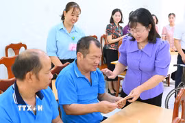 Bà Nguyễn Hoàng Uyên, Phó Giám đốc Sở Y tế Tây Ninh, thăm hỏi, trao quà hỗ trợ các đối tượng bảo trợ xã hội và người khuyết tật. (Ảnh: Thanh Bình/TTXVN)