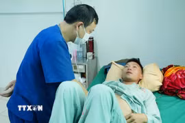 Bác sỹ thăm khám cho bệnh nhân Cứ A Sề bị ngộ độc do ăn nấm lạ. (Ảnh: Nguyễn Oanh/TTXVN)