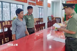 Cơ quan An ninh điều tra Công an tỉnh An Giang tống đạt lệnh khởi tố vụ án, khởi tố bị can, thực hiện lệnh bắt bị can tạm giam đối tượng Giang Chí Hùng. (Ảnh: TTXVN phát)