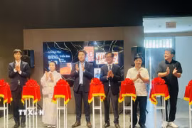 Các đại biểu thực hiện nghi thức cắt băng khai mạc triển lãm “Dáng hình của đất”. (Ảnh: Tuyết Mai/TTXVN)