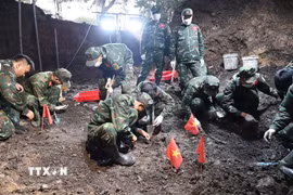 Cán bộ, chiến sỹ đội K74 triển khai công tác tìm kiếm, quy tập hài cốt liệt sỹ tại khu vực rãnh mộ tập thể của liệt sỹ mới được phát hiện. (Ảnh: Xuân Khu/TTXVN)
