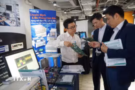 Các đại biểu tham quan triển lãm, giới thiệu các giải pháp phát triển công nghiệp bán dẫn, điện tử. (Ảnh: Thu Hoài/TTXVN)