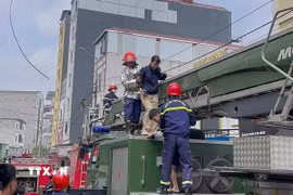 Khẩn trương giải cứu người khỏi đám cháy. (Ảnh: TTXVN phát)