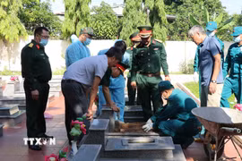 Lực lượng chức năng thực hiện khai quật, lấy mẫu hài cốt liệt sỹ tại các phần mộ chưa xác định thông tin tại Nghĩa trang liệt sỹ xã Cư Jút (tỉnh Lâm Đồng). (Ảnh: Nguyễn Huy Thành/TTXVN)