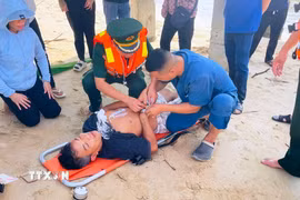 Các lực lượng, đơn vị phối hợp sơ cứu ngư dân có biểu hiện xuất huyết não khi đang hành nghề trên biển. (Ảnh: Võ Dung/TTXVN)