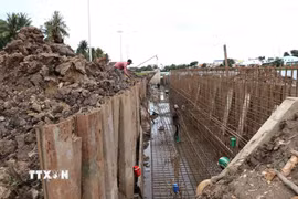 Công trình kè chống sạt lở bờ sông Láng Thé kết hợp khán đài đua ghe Ngo (phường Nguyệt Hóa) đang được đẩy nhanh tiến độ để hoàn thành, đưa vào sử dụng trong tháng 9/2026. (Ảnh: Thanh Hòa/TTXVN)