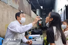 Bác sỹ Trạm Y tế xã Hiệp Phước khám, kiểm tra sức khỏe cho học sinh khu vực ghi nhận ca bệnh não mô cầu. (Ảnh: Đinh Hằng/TTXVN)