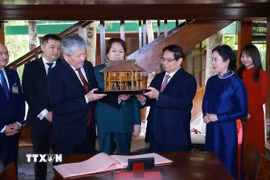 Thủ tướng Phạm Minh Chính tặng Thủ tướng Kyrgyzstan Adylbek Kasymaliev mô hình nhà sàn Bác Hồ. (Ảnh: Dương Giang/TTXVN)