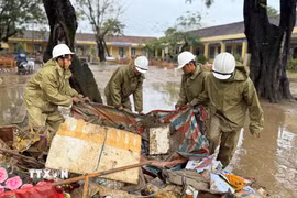 Lực lượng Quân đội hỗ trợ người dân thu dọn rác và bùn đất sau khi nước rút. (Ảnh: Nguyên Dung/TTXVN)