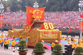 Xe mô hình Quốc huy nước Cộng hòa xã hội chủ nghĩa Việt Nam đi đầu khối diễu binh, diễu hành. (Ảnh: TTXVN)