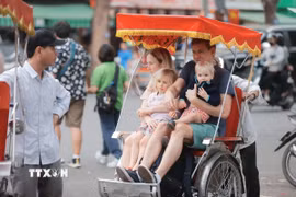 Du khách quốc tế tham quan Hà Nội bằng xích lô. (Ảnh: Minh Quyết/TTXVN)