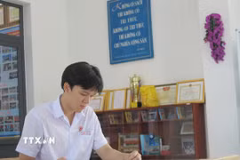 Đoàn Thanh Tùng học tập tại thư viện nhà trường. (Ảnh: Phan Sáu/TTXVN)
