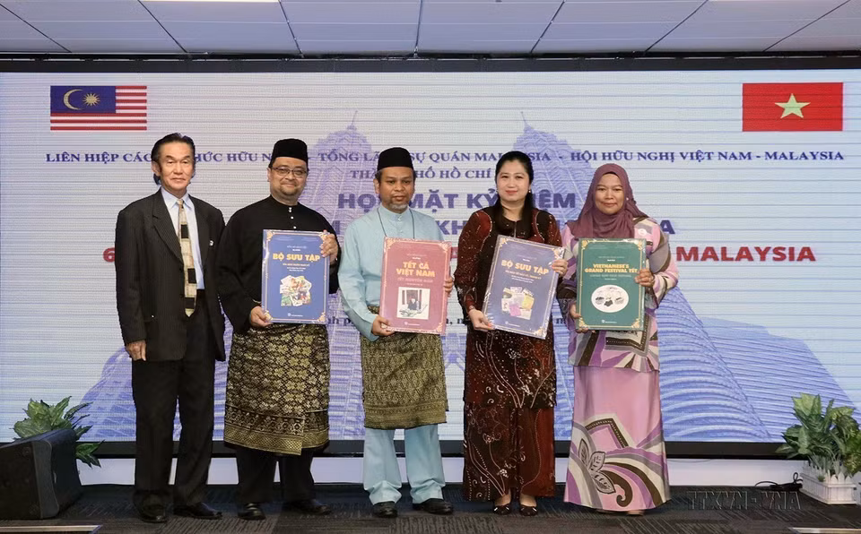 Tổng lãnh sự Wong Chia Chiann và các nhân viên Tổng lãnh sự quán Malaysia tại TP Hồ Chí Minh nhận sách giới thiệu về Tết truyền thống Việt Nam tại buổi họp mặt kỷ niệm lần thứ 65 ngày Quốc khánh Malaysia, ngày 9/9/2022. (Ảnh: Xuân Khu/TTXVN)