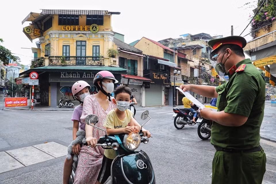 Công an phường Hàng Buồm, quận Hoàn Kiếm kiểm tra chặt chẽ giấy xác nhận đi đường theo quy định mới. (Ảnh: Thành Đạt/TTXVN)